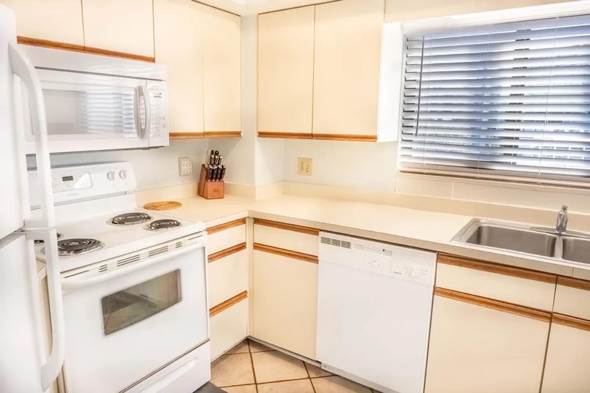 A comfortable kitchen scene centered on a stove, sink, dishwasher, and organized countertops. The space signals readiness for family cooking, entertaining guests, or experimenting with new recipes.