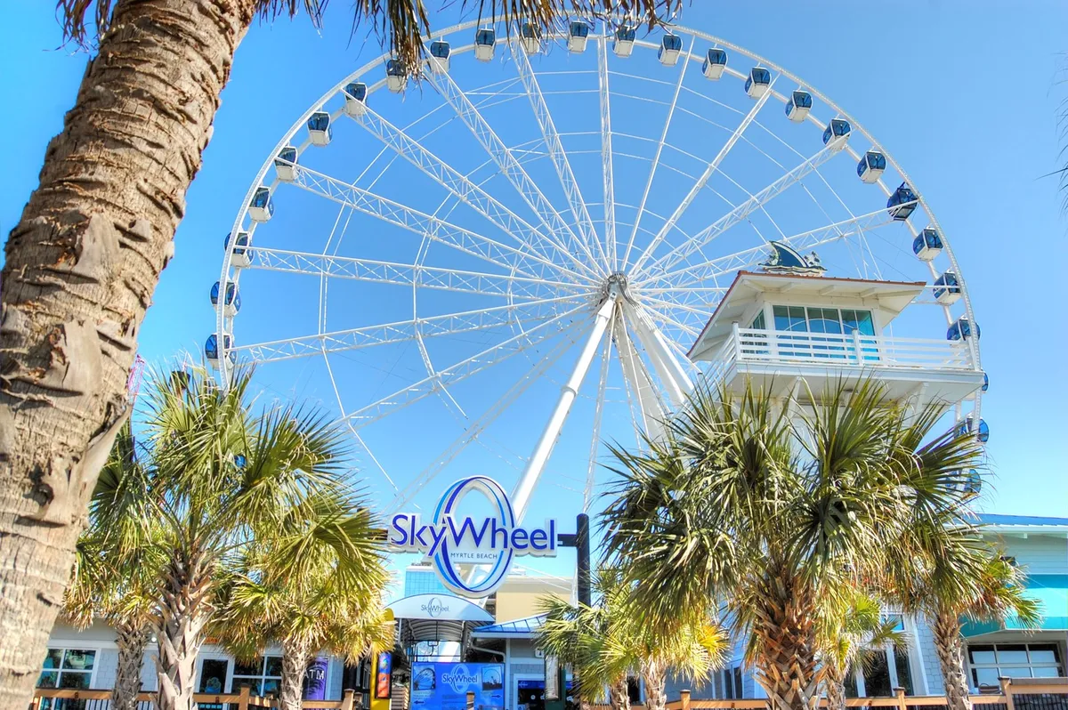 This exterior shot showcases the SkyWheel, entrance area, and palm trees, capturing the excitement of one of Myrtle Beach’s signature attractions. The joyful mood and iconic feature evoke the thrill of shared adventures and complimentary daily activities available to guests.